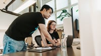 A Vaadin employee helping their colleague out by a desk. A Vaadin employee helping their colleague out by a desk.